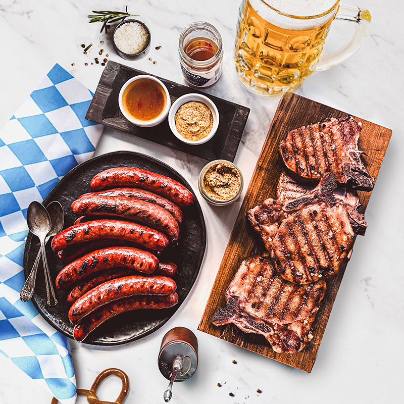 Oktoberfest pack displayed on plates and cutting board with a stein of beer and a Bavarian napkin