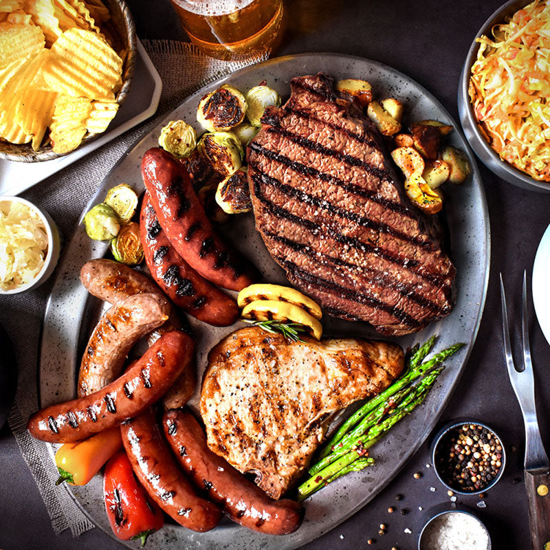 backyard barbeque on a silver platter with various sides served with it