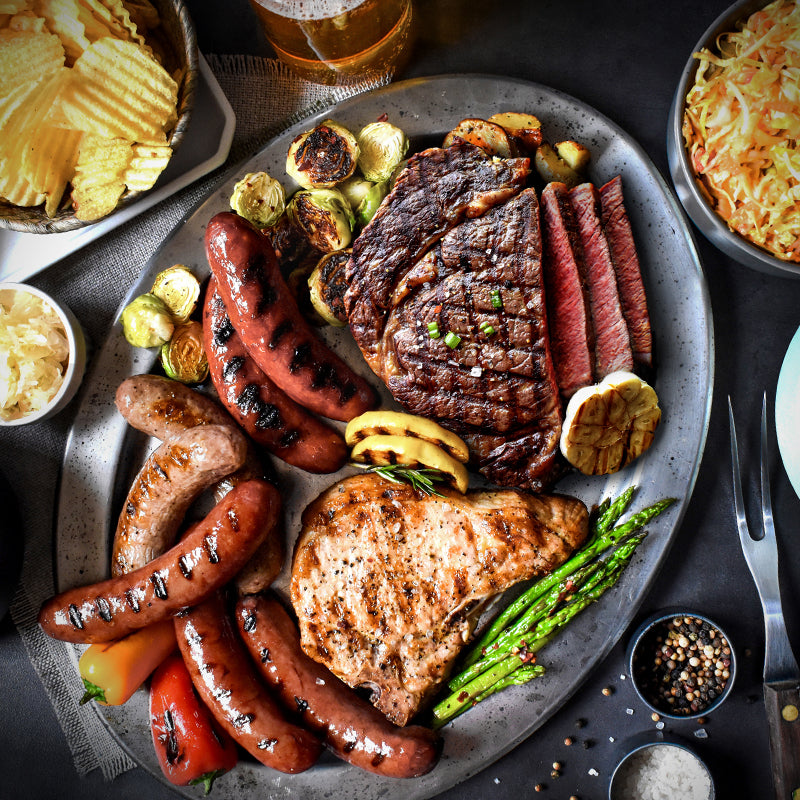 backyard barbeque on a silver platter with various sides served with it