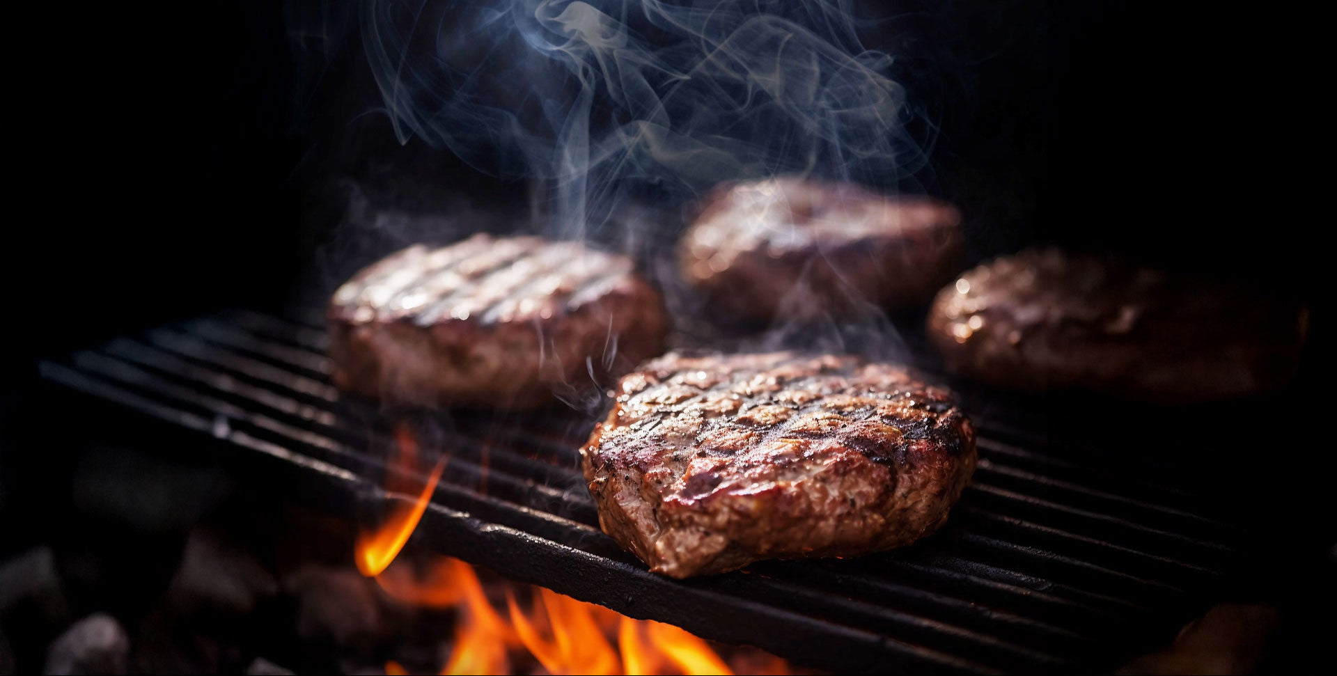 steaks grilling on a charcoal grill with fire