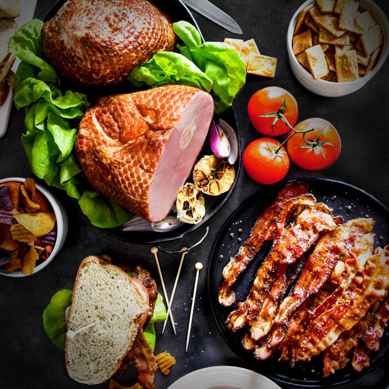 taste of the heartland in a serving tray and on a black plate served with bread as a sandwich and chips and crackers