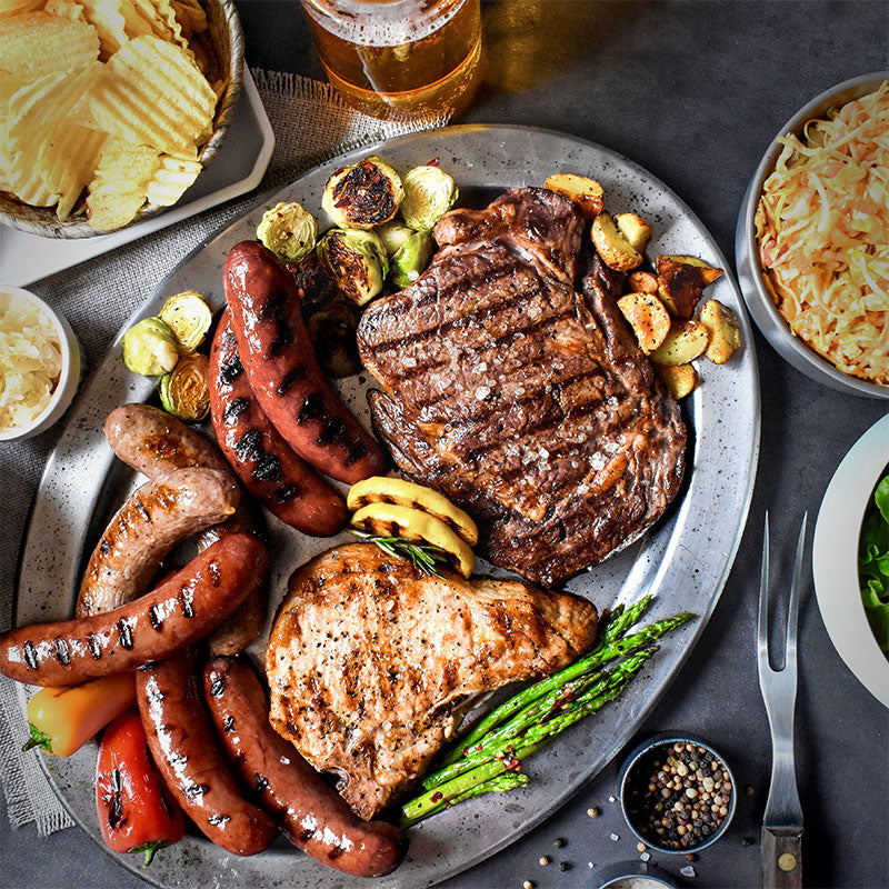 backyard barbeque on a silver platter with various sides served with it