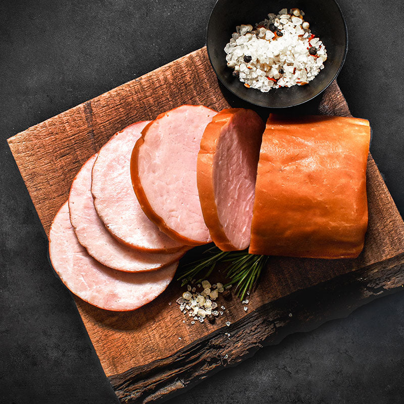 sliced chunk of smoked Canadian-style bacon on serving board