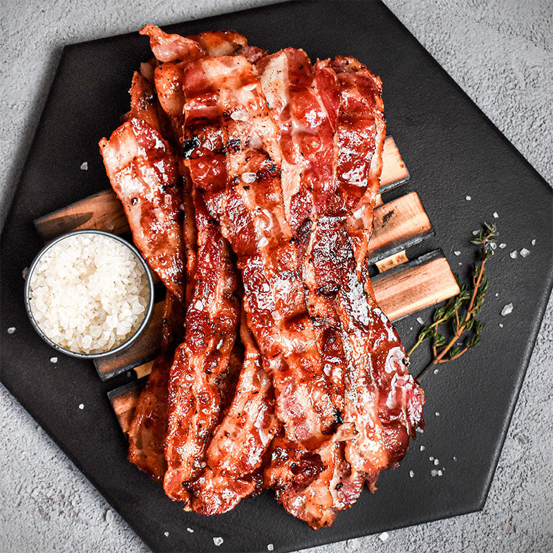 smoked bacon stacked on a black tray