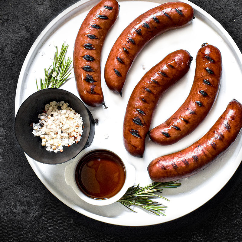 maple sausage brat served on a white plate with spices and sauce