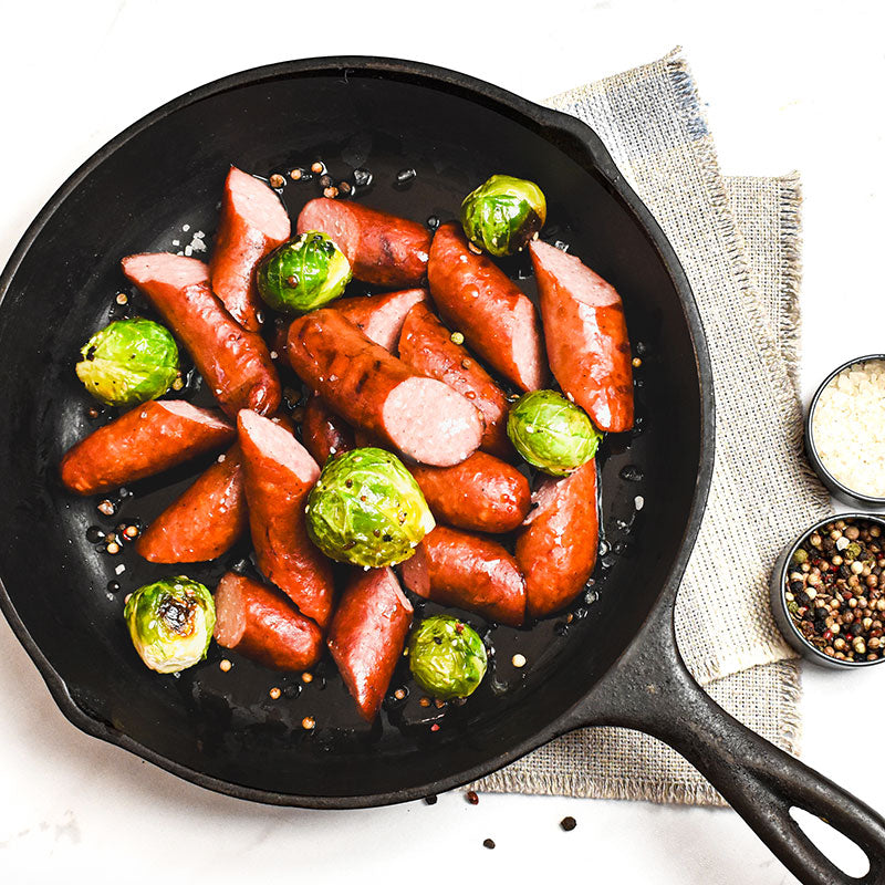 polish-style bratwurst with brussels sprouts in a skillet