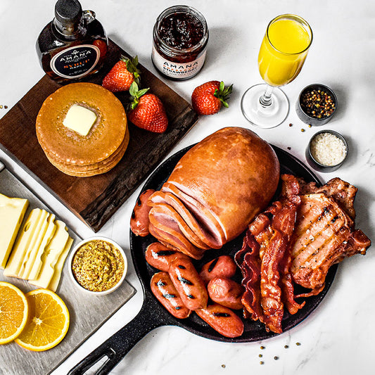 overhead shot of brunch pack on a black plate with pancakes and strawberries on a wooden board