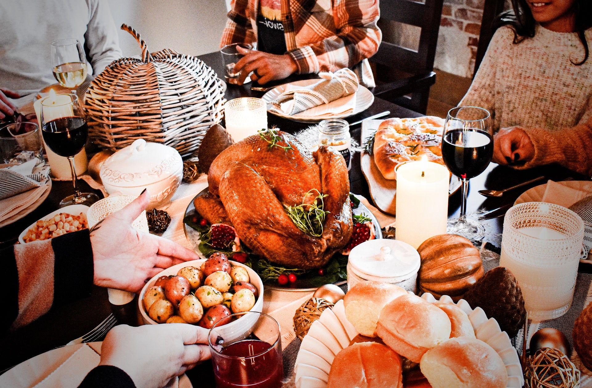 People gathered around a table for a Thanksgiving meal with an Amana smoked turkey.