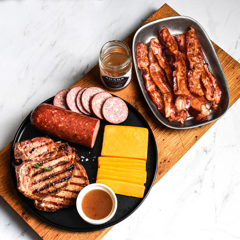 sampler of favorites bundle items on a black plate with bacon in metal dish