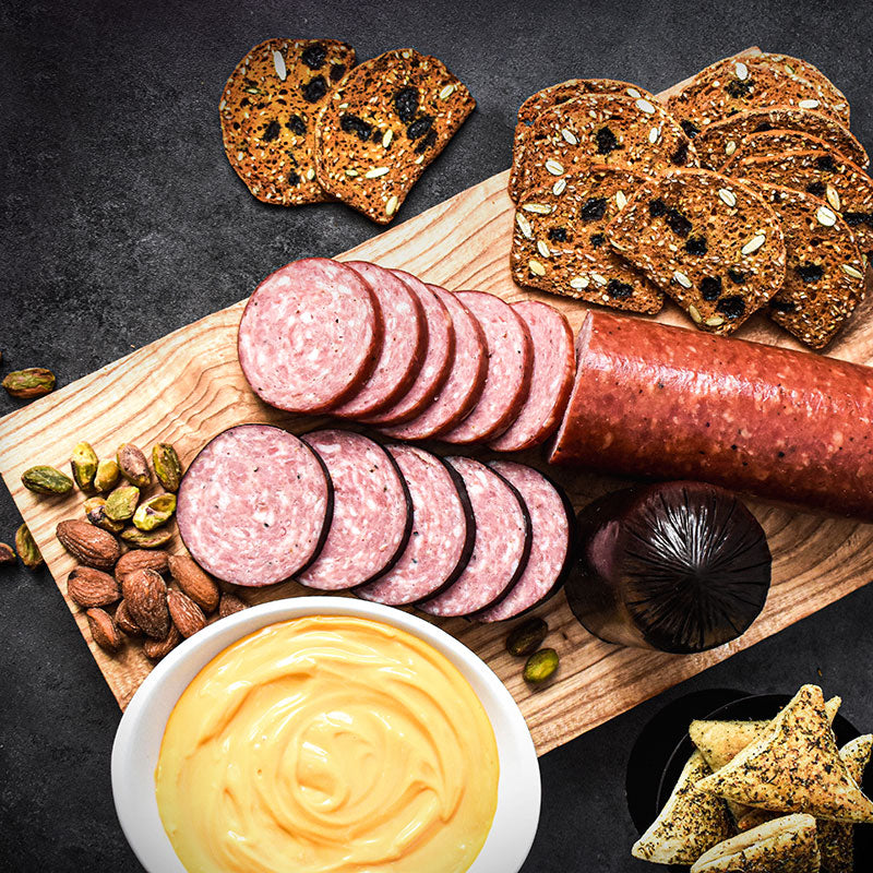 sausage and cheese combo on a cutting board with bread slices