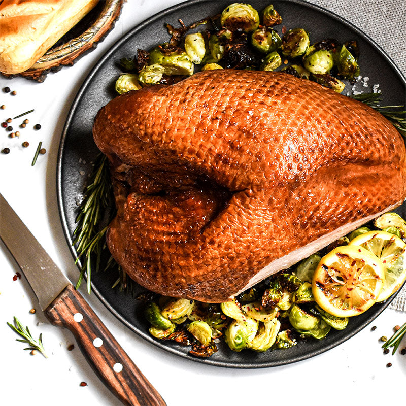 5-6 pound smoked turkey breast served with vegetables on a black plate