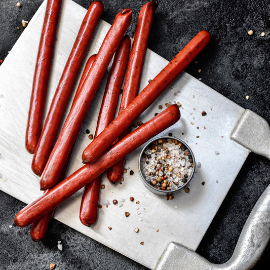 snack sticks spread out on a metal sheet with salt and pepper