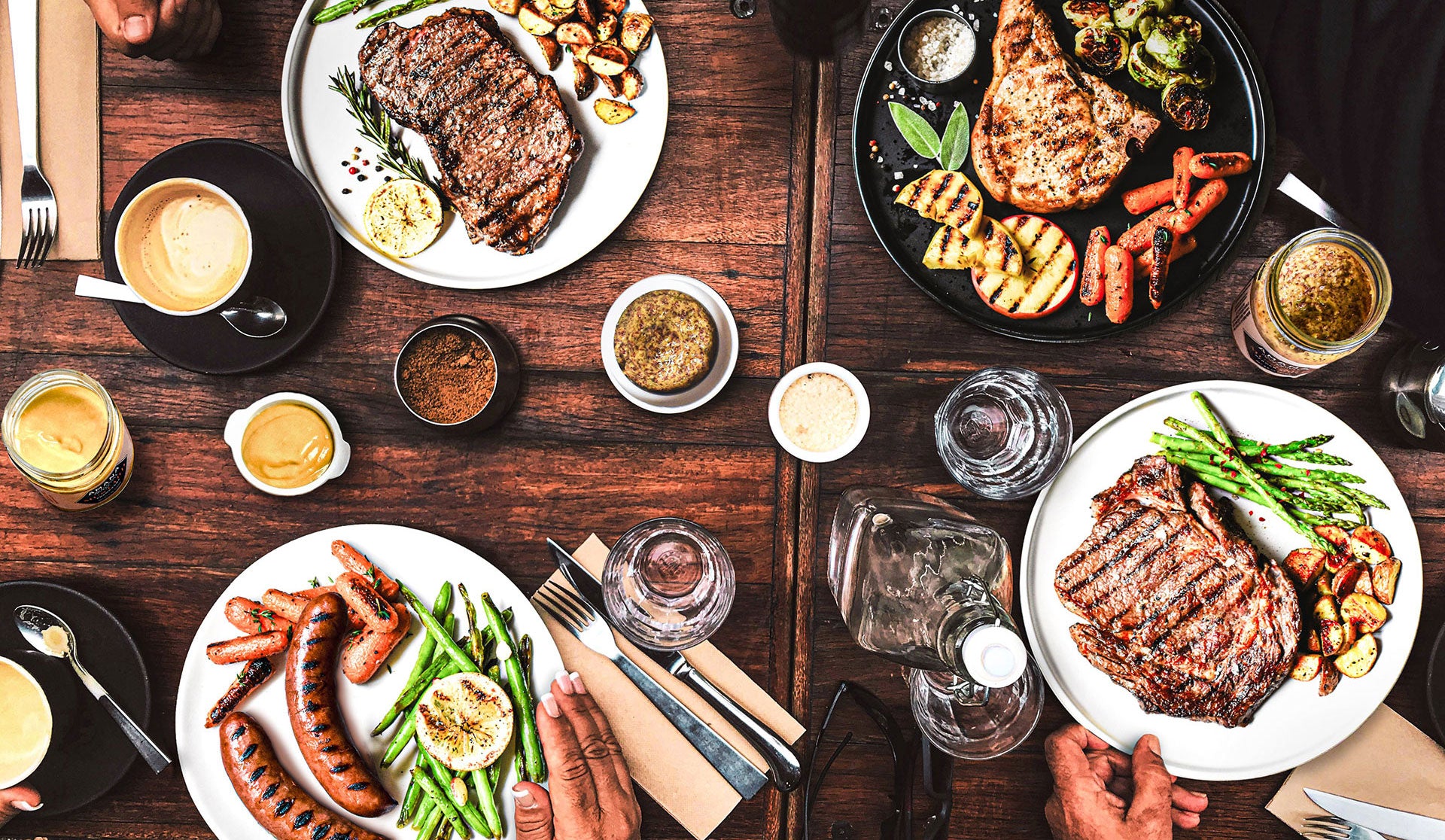 table full of food on plates and drinks and sauces