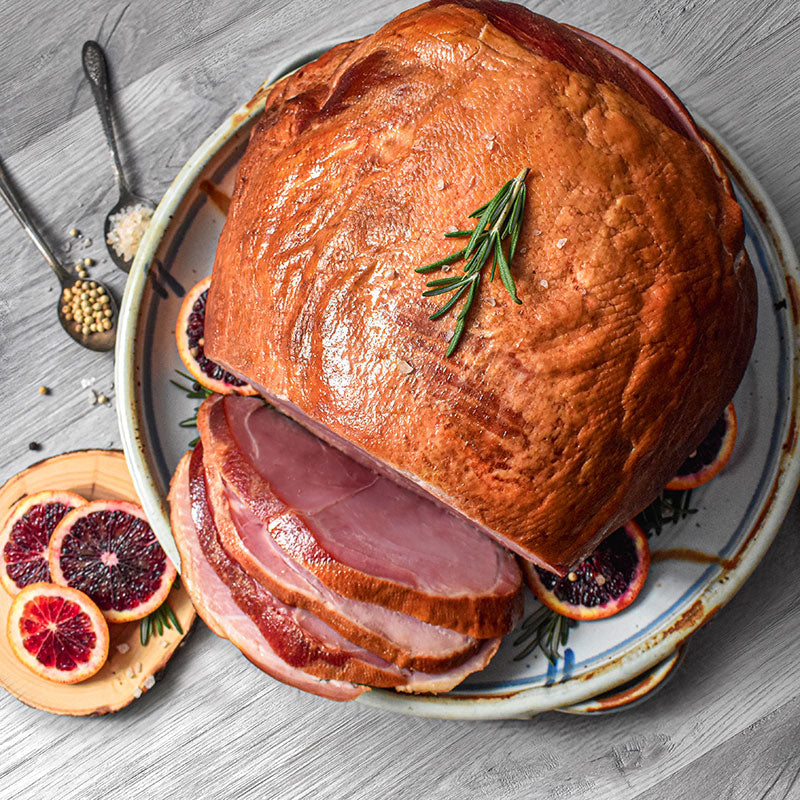 whole bone-in ham sliced on a serving plate